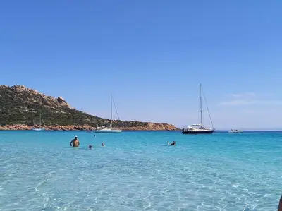 a group of people swimming in the ocean with boats at Studio climatisée dans résidence à 5 minutes des plages a pied in Propriano