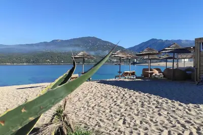a view of a beach with umbrellas and the water at Studio climatisée dans résidence à 5 minutes des plages a pied in Propriano