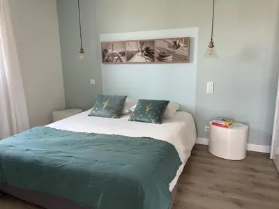 a bedroom with a bed with a green comforter at La Sté in Porticcio