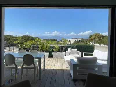 a patio with a table and chairs on a balcony at La Sté in Porticcio