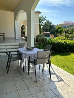 a white table and chairs on a patio at Appartement bord de mer avec piscine privee Porticcio in Porticcio
