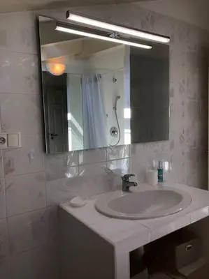 a bathroom with a sink and a mirror at Appartement bord de mer avec piscine privee Porticcio in Porticcio