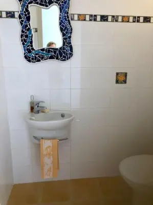a bathroom with a sink and a mirror on the wall at Appartement bord de mer avec piscine privee Porticcio in Porticcio
