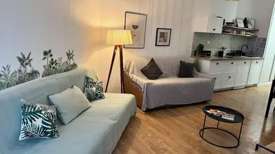 a living room with a couch and a table at Studio pied dans l'eau - WIFI- Piscine in Santa-Lucia-di-Moriani