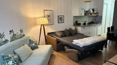a living room with a couch and a table at Studio pied dans l'eau - WIFI- Piscine in Santa-Lucia-di-Moriani