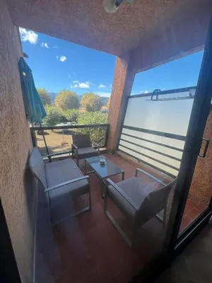 a view of a balcony with chairs and a table at Studio pied dans l'eau - WIFI- Piscine in Santa-Lucia-di-Moriani