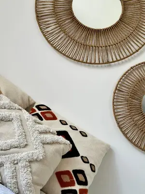 a room with two mirrors and pillows on a wall at Appartement Agosta Plage in Porticcio
