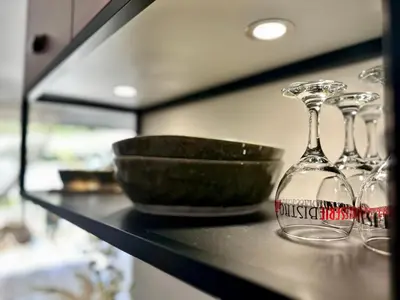a shelf with three wine glasses and a bowl on it at Appartement Agosta Plage in Porticcio