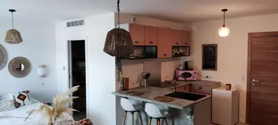 a kitchen with a counter and some chairs in a room at Appartement Agosta Plage in Porticcio