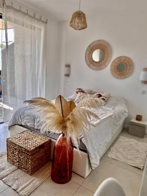 a bedroom with a bed and a vase with a bow at Appartement Agosta Plage in Porticcio