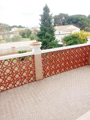 a fence with a stone wall on a balcony at HAUT VILLA MESANGES EN BORD DE MER ! in Lucciana