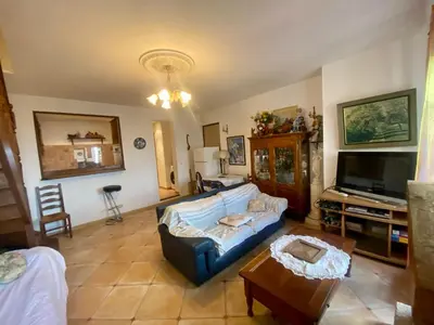 a living room with a blue couch and a tv at Charmant appartement T2 65m² in Quenza