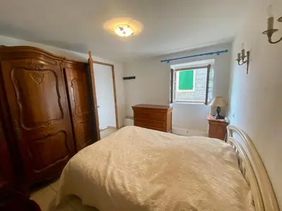 a bedroom with a bed and a dresser and a window at Charmant appartement T2 65m² in Quenza