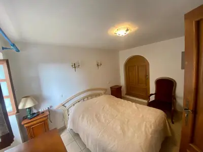 a bedroom with a bed and a desk and a chair at Charmant appartement T2 65m² in Quenza
