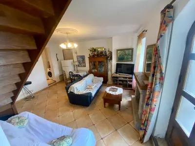 a living room with a couch and a tv at Charmant appartement T2 65m² in Quenza