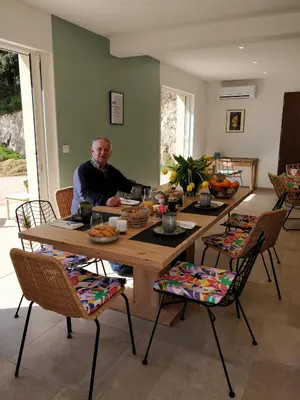 a man sitting at a table in a living room at Casa voscia in Casalabriva
