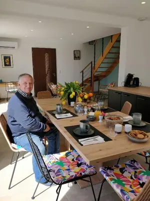a man sitting at a table in a living room at Casa voscia in Casalabriva