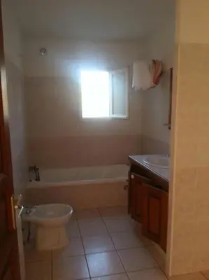 a bathroom with a toilet and a tub and a sink at bas de villa de 90m² entre mer (2km) et montagne in Talasani