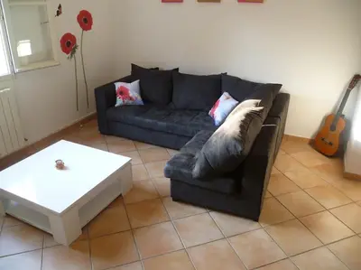 a living room with a couch and a coffee table at bas de villa de 90m² entre mer (2km) et montagne in Talasani