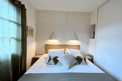 a bedroom with a bed with white sheets and pillows at Maison de maitre au charme d'antan Bonifacio in Bonifacio