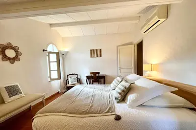 a bedroom with a large bed and a window at Maison de maitre au charme d'antan Bonifacio in Bonifacio