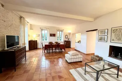 a living room with a television and a table at Maison de maitre au charme d'antan Bonifacio in Bonifacio