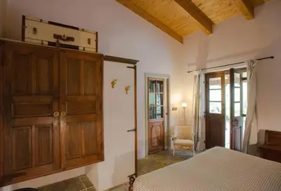 a bedroom with a bed and a wooden cabinet at Villa con piscina tra Porto vecchio e Bonifacio in Figari
