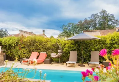 a patio with chairs and an umbrella next to a pool at VILLA tous conforts avec Piscine privée et accès Plage in Cervione