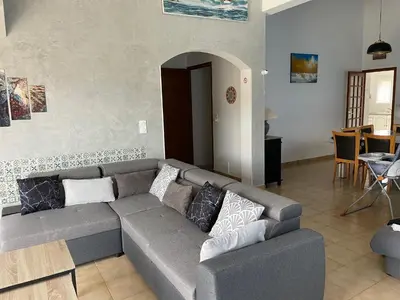 a living room with a gray couch and a table at VILLA tous conforts avec Piscine privée et accès Plage in Cervione