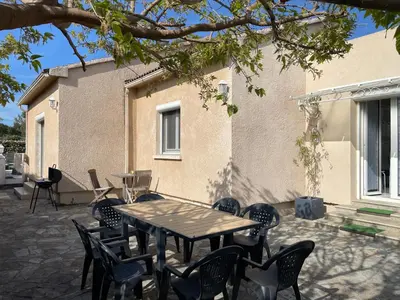 a table and chairs in front of a building at VILLA tous conforts avec Piscine privée et accès Plage in Cervione