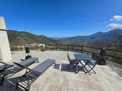 a table and chairs on a patio with a view at Casa Punta Di Vista in Venaco
