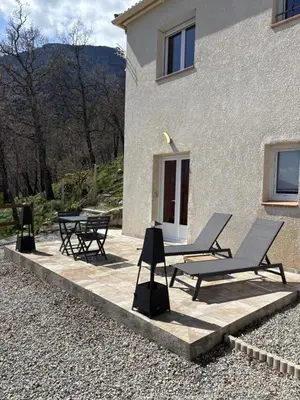 a patio with two lounge chairs and a table at Casa Punta Di Vista in Venaco