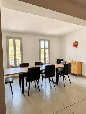 a dining room with a wooden table and chairs at Magnifique T3 les hauts du port Bonifacio in Bonifacio