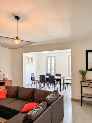 a living room with a couch and a dining room at Magnifique T3 les hauts du port Bonifacio in Bonifacio