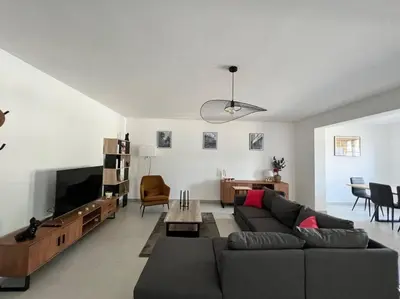 a living room with a couch and a tv at Magnifique T3 les hauts du port Bonifacio in Bonifacio