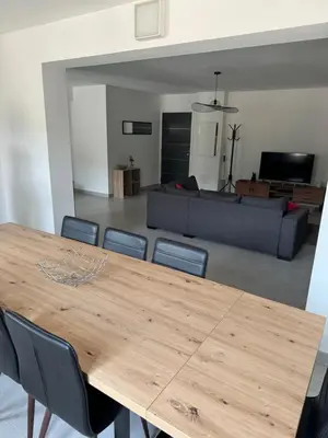 a table and chairs in a living room with a couch at Magnifique T3 les hauts du port Bonifacio in Bonifacio
