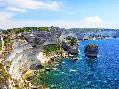 an aerial view of a rocky shore with blue water at Magnifique T3 les hauts du port Bonifacio in Bonifacio