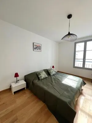a bedroom with a large green bed in a room at Magnifique T3 les hauts du port Bonifacio in Bonifacio
