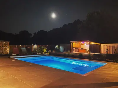 a swimming pool in a yard at night at Villas Vallée d'ASCO in Moltifao