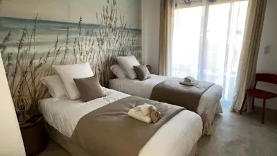 a hotel room with two beds with towels on them at Villas Vallée d'ASCO in Moltifao