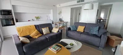 a living room with two couches and a table at NEPITA- Vue mer- piscine en résidence de standing- clim-Wifi in Sari Solenzara