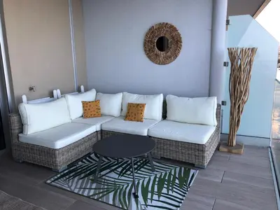 a living room with a couch and a table at NEPITA- Vue mer- piscine en résidence de standing- clim-Wifi in Sari Solenzara