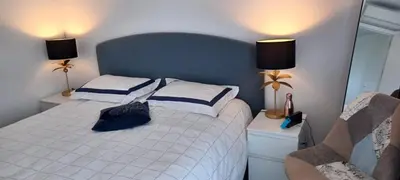 a bedroom with a white bed with a blue headboard at NEPITA- Vue mer- piscine en résidence de standing- clim-Wifi in Sari Solenzara