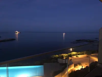 a view of the ocean at night from a building at NEPITA- Vue mer- piscine en résidence de standing- clim-Wifi in Sari Solenzara