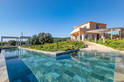 a swimming pool in front of a building at Villa La Ronde des Soleils in Coti-Chiavari