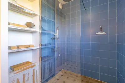 a blue tiled bathroom with a shower at Villa La Ronde des Soleils in Coti-Chiavari