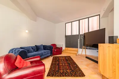 a living room with a couch and a flat screen tv at Villa La Ronde des Soleils in Coti-Chiavari
