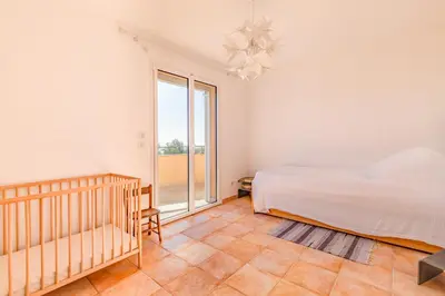 a bedroom with a bed and a large window at Villa La Ronde des Soleils in Coti-Chiavari