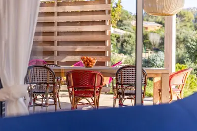 a wooden table and chairs on a patio at Villa La Ronde des Soleils in Coti-Chiavari