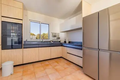 a large kitchen with a sink and a window at Villa La Ronde des Soleils in Coti-Chiavari